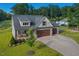 Home with three-car garage, comfortable front porch and spacious driveway surrounded by mature trees and manicured lawns at 178 Greenwich Dr, Sanford, NC 27330