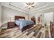 Main bedroom featuring wood flooring, tray ceiling, ceiling fan and matching furniture at 178 Greenwich Dr, Sanford, NC 27330