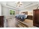 Main bedroom featuring wood flooring, tray ceiling, ceiling fan and natural lighting at 178 Greenwich Dr, Sanford, NC 27330
