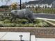 A striking metal bull sculpture is set in a landscaped community area with parking spaces and modern homes in the background at 2106 Pink Peony Cir # 146, Durham, NC 27703