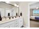 Bathroom featuring double sinks, a large mirror with modern lighting, and a view into an adjacent bedroom at 241 Teague St, Wake Forest, NC 27587