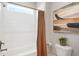 Bathroom with a bathtub, shower with brown curtain, toilet, and a decorative plant, well-lit by a window above at 241 Teague St, Wake Forest, NC 27587