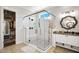 Modern bathroom with a glass-enclosed shower, walk-in closet, decorative mirror, and sleek vanity at 241 Teague St, Wake Forest, NC 27587