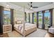 Bright bedroom featuring a four-poster bed, ceiling fan, and an abundance of natural light from large windows at 241 Teague St, Wake Forest, NC 27587