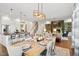 Open-concept dining room showcasing a modern chandelier, light wood table, and seamless flow into the kitchen and living area at 241 Teague St, Wake Forest, NC 27587