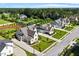 Aerial view of a modern farmhouse-style home with manicured lawn, mature trees, and a long driveway at 241 Teague St, Wake Forest, NC 27587