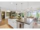 Bright, open-concept kitchen featuring a large island with a sink and seating, and easy access to dining room and living room at 241 Teague St, Wake Forest, NC 27587