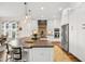 Gourmet kitchen showcasing a large island with seating, stainless steel appliances, custom cabinetry, and modern lighting at 241 Teague St, Wake Forest, NC 27587