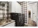 Well-equipped laundry room with modern washer and dryer, white cabinets, patterned wallpaper, and a sink at 241 Teague St, Wake Forest, NC 27587