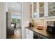 Butler's pantry with glass-front cabinets, open desk space, beverage cooler, and tiled backsplash at 241 Teague St, Wake Forest, NC 27587