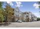 View of a multi-story condo building with garages and balconies under a blue sky at 2810 Bedford Green Dr # 5, Raleigh, NC 27604