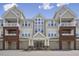 Attractive multi-story condo building featuring garages, balconies, and a welcoming entrance under a clear sky at 2810 Bedford Green Dr # 5, Raleigh, NC 27604