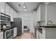 Galley kitchen featuring white cabinets, stainless steel appliances, and granite countertops with laundry closet at 2810 Bedford Green Dr # 5, Raleigh, NC 27604