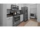 Galley kitchen showcasing stainless steel appliances, granite countertops, white cabinets, and tile flooring at 2810 Bedford Green Dr # 5, Raleigh, NC 27604
