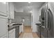 Galley kitchen showcasing stainless steel appliances, granite countertops, white cabinets, and tile flooring at 2810 Bedford Green Dr # 5, Raleigh, NC 27604
