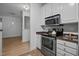Galley kitchen featuring stainless steel appliances, granite countertops, white cabinets, and tile flooring at 2810 Bedford Green Dr # 5, Raleigh, NC 27604