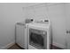 Well-lit laundry room featuring modern washer and dryer units with overhead storage shelving at 2810 Bedford Green Dr # 5, Raleigh, NC 27604