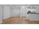 Bright living room and kitchen featuring white cabinets, stainless steel appliances, and wood-look floors at 2810 Bedford Green Dr # 5, Raleigh, NC 27604