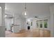 Bright living room and kitchen featuring white cabinets, stainless steel appliances, wood-look floors, and a fireplace at 2810 Bedford Green Dr # 5, Raleigh, NC 27604