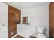 Bathroom features wood paneling, white cabinetry and toilet, and wood laminate flooring at 2927 S Church St, Rocky Mount, NC 27803