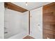 Bathroom including a shower-tub, wood laminate flooring, and wood paneling at 2927 S Church St, Rocky Mount, NC 27803