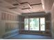 Bright, unfinished bedroom showcasing a large window and modern tray ceiling during renovations at 3004 William Frederick Way, Raleigh, NC 27603