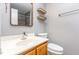 Bathroom with an undermount sink, wood shelves, and framed mirror at 303 Applecross Dr, Cary, NC 27511
