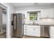 Bright kitchen with stainless steel appliances, white cabinetry, and a garden window view at 303 Applecross Dr, Cary, NC 27511