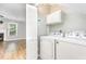 Functional laundry area with appliances, storage cabinets, and easy access to the living room at 303 Applecross Dr, Cary, NC 27511