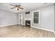 Cozy living room with hardwood floors, fireplace, ceiling fan, and large windows for ample natural light at 303 Applecross Dr, Cary, NC 27511