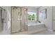 Well-lit bathroom features a glass shower, soaking tub, and large window providing natural light and privacy at 318 Riggsbee Farm Dr, Cary, NC 27519