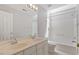 Bright bathroom features a double vanity, tiled floor, and a bathtub with a shower combo and tiled walls at 318 Riggsbee Farm Dr, Cary, NC 27519