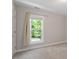 Minimalist bedroom features neutral walls, plush carpeting, and a window offering natural light and views at 318 Riggsbee Farm Dr, Cary, NC 27519