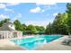 Large community pool and clubhouse, surrounded by lush greenery and comfortable lounge chairs at 318 Riggsbee Farm Dr, Cary, NC 27519