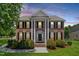 Traditional two-story brick home with stately columns, well-maintained lawn and landscaping at 318 Riggsbee Farm Dr, Cary, NC 27519