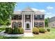 Stunning brick home with white columns, black shutters, and a well-manicured front lawn at 318 Riggsbee Farm Dr, Cary, NC 27519