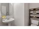 Cozy powder room features a pedestal sink, decorative mirror, and a convenient toilet with stylish shelving at 318 Riggsbee Farm Dr, Cary, NC 27519