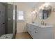 Bathroom featuring double sinks, white cabinets, wood-style tile floor, and glass walk-in shower at 3421 Tunas St, Raleigh, NC 27616