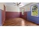 Spacious bedroom features hardwood floors, two windows, ceiling fan and custom wainscoting at 3421 Tunas St, Raleigh, NC 27616