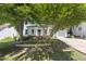 Beautiful two-story home with a white exterior, front porch, and mature trees in the yard at 3421 Tunas St, Raleigh, NC 27616