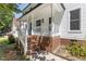 Charming front porch with brick stairs, white railings, and a view of the home's exterior at 3421 Tunas St, Raleigh, NC 27616