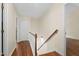 Upstairs hallway with hardwood floors, wooden banister and a closet with access panel in the ceiling at 3421 Tunas St, Raleigh, NC 27616