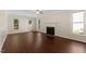 Living room with a traditional fireplace, ceiling fan, and beautiful dark wood floors and natural light at 3421 Tunas St, Raleigh, NC 27616