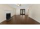 Spacious living room featuring beautiful dark wood floors, fireplace and French doors to a back patio at 3421 Tunas St, Raleigh, NC 27616