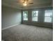 Spacious bedroom features neutral carpet, three windows, and a ceiling fan at 3509 Bailey Lake Dr, Fuquay Varina, NC 27526