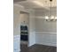 Formal dining room with wainscoting, coffered ceiling, and modern chandelier at 3509 Bailey Lake Dr, Fuquay Varina, NC 27526
