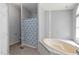 Bathroom featuring a soaking tub and shower with blue and white shower curtain at 40 Raccoon Xing, Henderson, NC 27537