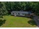 Charming single Gathering home features a covered porch and yard surrounded by lush forest at 40 Raccoon Xing, Henderson, NC 27537