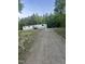 Gravel driveway leads up to the white house surrounded by trees at 4025 Royal Dr, Franklinton, NC 27525