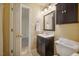 Bathroom with single vanity, mirror, dark wood cabinet and toilet at 4117 Olde Coach Rd, Durham, NC 27707